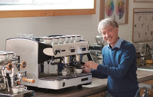 lachender Mann an Espessomaschine